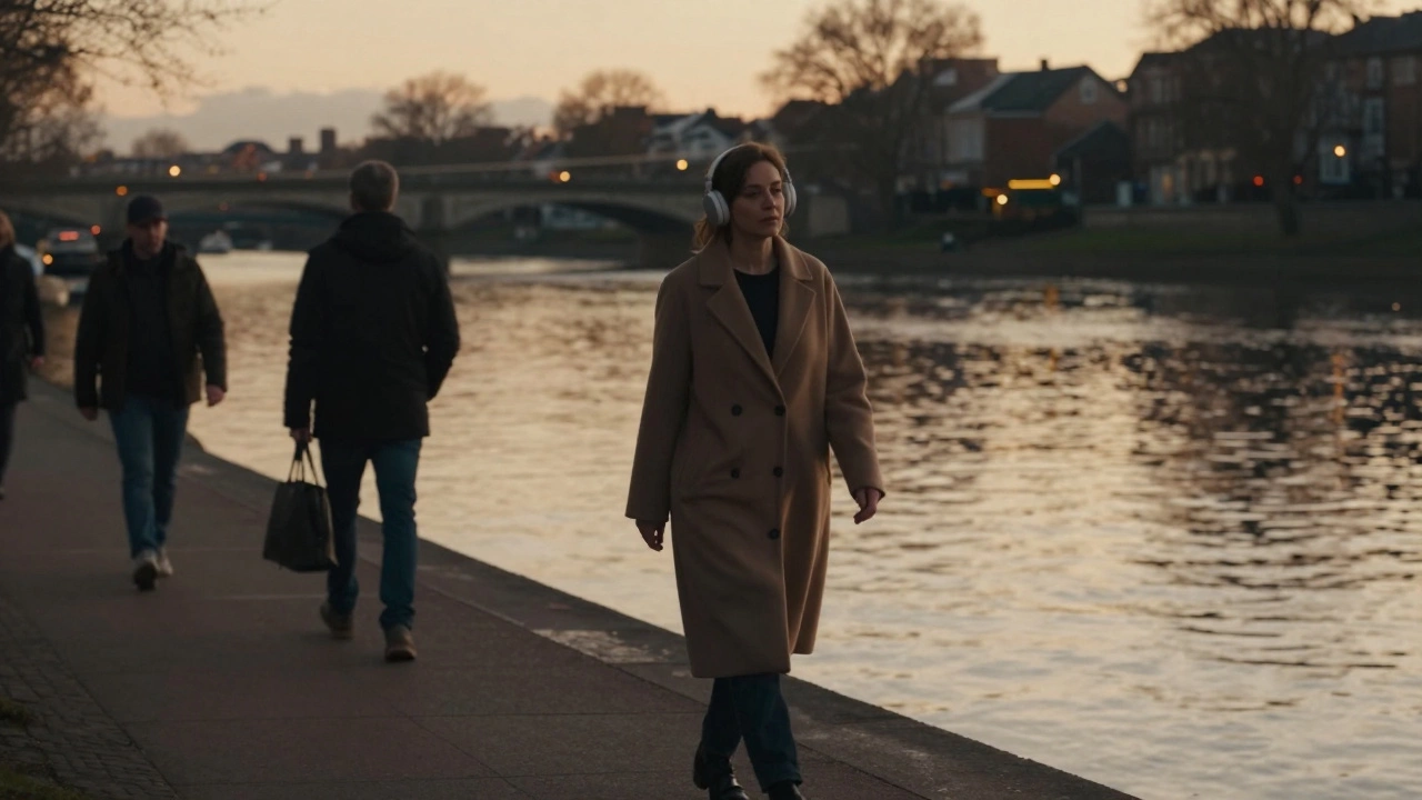 A woman walking alone by a river at sunset, calm and self-assured.
